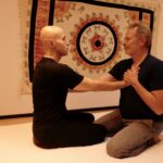 two people with hands on each others hearts in Chi Works Massage Studio.
