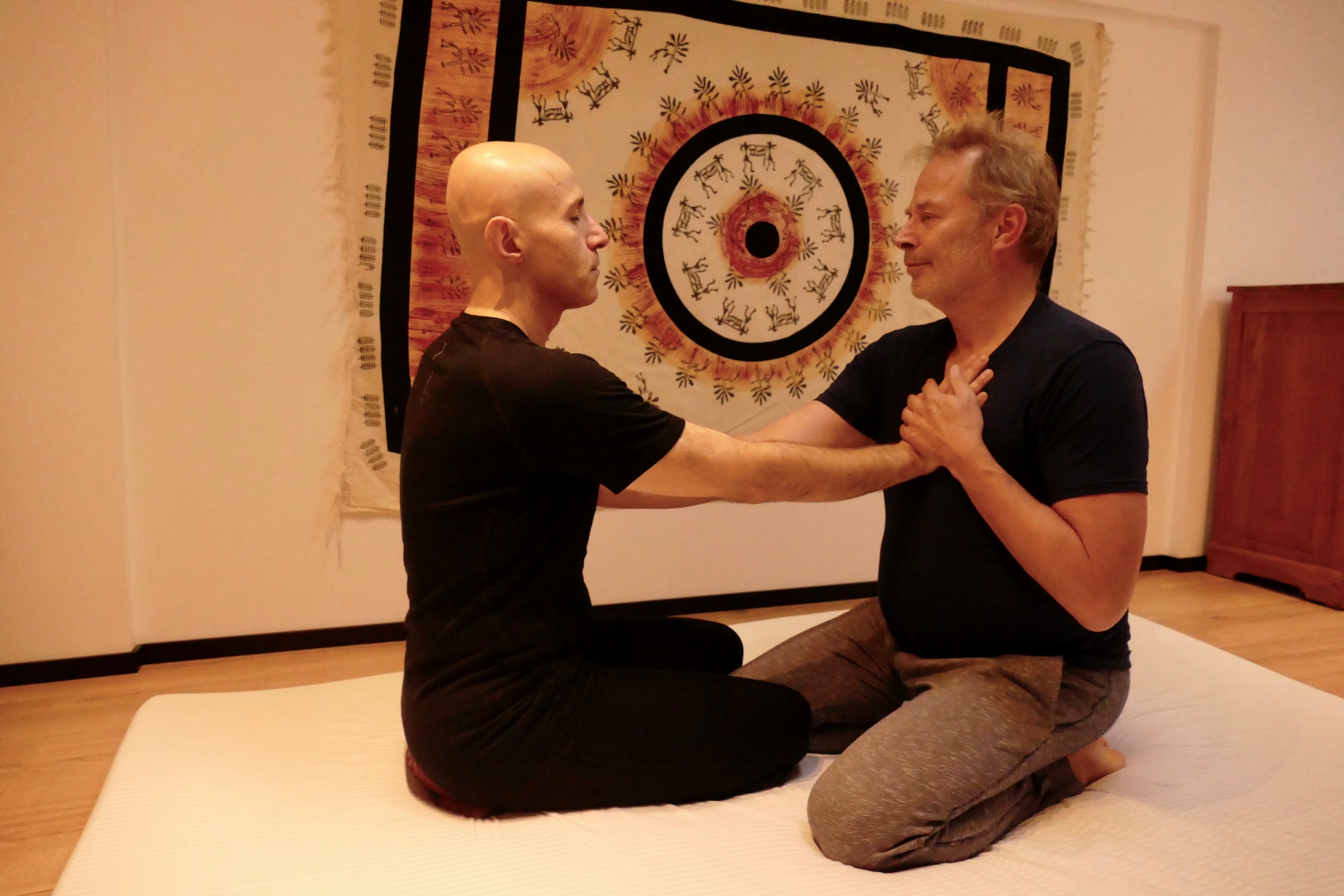 two people with hands on each others hearts in Chi Works Massage Studio.